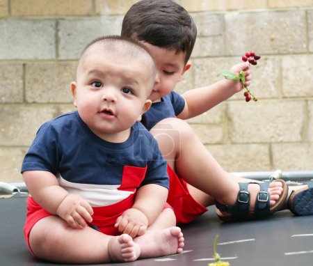 Téléchargez les photos : Vieux de 2 ans et 4 mois Les Bébés Frères profitent du trampoline dans le Home Garden par une belle journée au-dessus de Luton, Angleterre Royaume-Uni. Superbe gros plan L'image a été capturée le 23 juillet 2023 - en image libre de droit