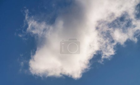 Téléchargez les photos : Nuages pelucheux blancs sur le fond bleu ciel - en image libre de droit