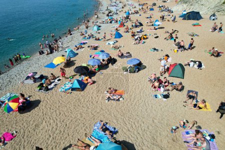 Foto de Vista aérea de la gente está disfrutando del caluroso día de verano de Inglaterra en la puerta de Durdle Natural Beach durante sus vacaciones. Hermosa atracción turística capturada con la cámara del dron el 9 de septiembre de 2023, Inglaterra - Imagen libre de derechos