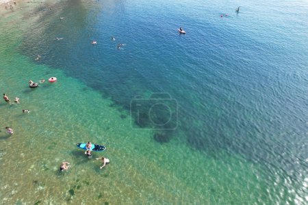 Photo for Aerial View of People are Enjoying Hot Summer Day of England at Durdle door Natural Beach During Their Holidays. Beautiful Tourist Attraction Captured with Drone's Camera on Sep 9th, 2023, England UK - Royalty Free Image