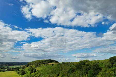 Foto de Más bella y mejor vista de ángulo alto de nubes dramáticas y gruesas y cielo azul sobre la campiña británica en Sharpenhoe Clappers cerca de la ciudad de Luton, Inglaterra. 24 de junio de 2023 Durante el Atardecer - Imagen libre de derechos