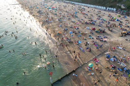 Foto de Vista aérea de muchas personas están disfrutando del caluroso día de verano sobre Inglaterra en Bournemouth Sandy Beach durante sus vacaciones. Atracción turística más hermosa capturada con la cámara del dron el 9 de septiembre de 2023, Inglaterra - Imagen libre de derechos