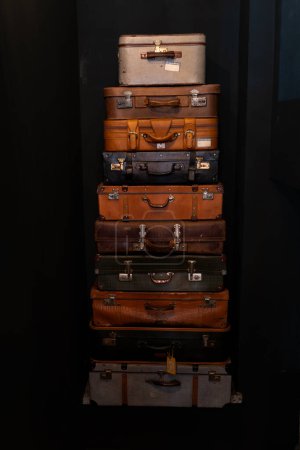 Haufen alter bunter Koffer auf dunkelblauem Hintergrund