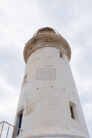 White lighthouse and white cloudy sky as a background