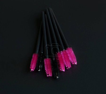 Pink eyelashes extension brush isolated on black background. Brush for combing eyelashes. brush for straightening eyelashes and eyebrows.