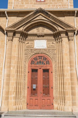Red old door of antique Cypriot church in north Nicosia. Cyprus. Church arch and columns