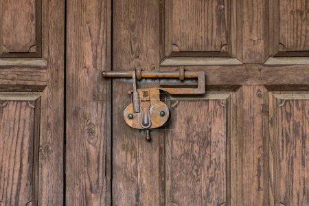Téléchargez les photos : Serrure rouillée vintage verrouillant une porte en bois rustique fermée - en image libre de droit