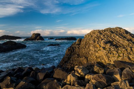 Téléchargez les photos : Mer et littoral rocheux illuminés par une lumière du soir spectaculaire au port de Ballintoy, Irlande du Nord - en image libre de droit
