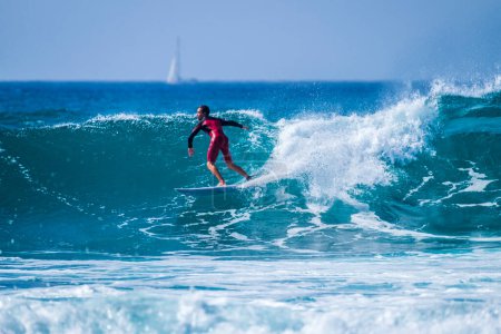 Téléchargez les photos : Adolescent surfant sur la vague dans la plage tenerife des États-Unis combinaisons rouges et belle vague parfaite freestyle et faire des tours - en image libre de droit