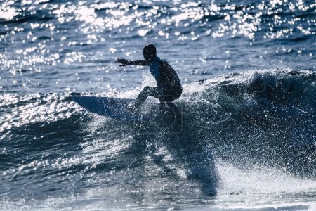 Foto de Surf adolescente en la ola en la playa de tenerife de las Américas - trajes de neopreno blancos y negros y ola hermosa y pequeña - Imagen libre de derechos