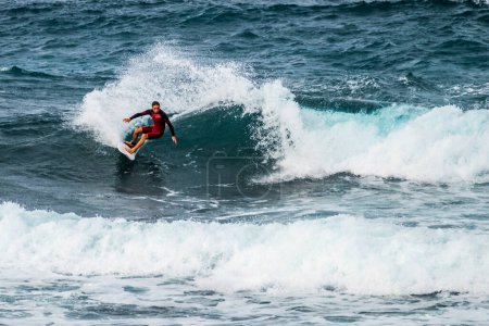 Foto de Un hombre montando una ola azul grande y extrema en el océano - hora de verano y disfrutar de las vacaciones - Imagen libre de derechos