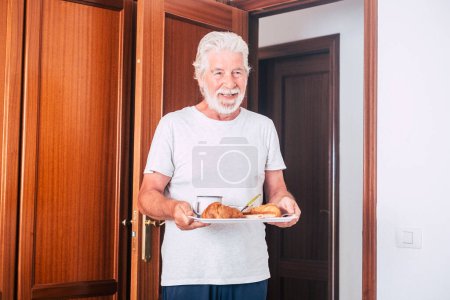 Mann zu Hause wacht einfach auf und reifer Mann steht früh auf, um das Frühstücksbett bei seiner Frau zu machen - älterer Herr und Rentner  