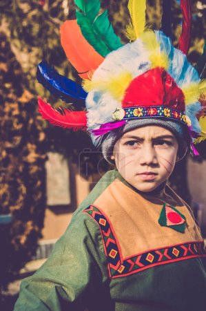 Boy dressed as a Native American Indian shows grimaces 