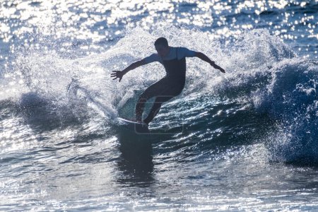 Foto de Un hombre entrenando y surfeando en vacaciones en verano o invierno usando traje de neopreno - ola hermosa y grande en la isla canaria - Imagen libre de derechos
