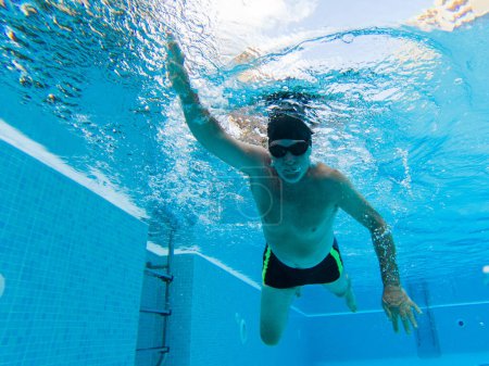 Foto de Un anciano activo solo en la piscina natación y entrenamiento para estar sano y un hombre de fitness - verano divertirse en la piscina - Imagen libre de derechos