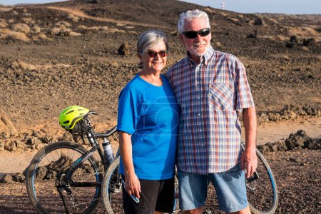 Zwei Senioren heirateten zusammen und schauten sich mit ihren beiden Fahrrädern den felsigen Berg an. Lebensstil für reife Männer und Frauen 