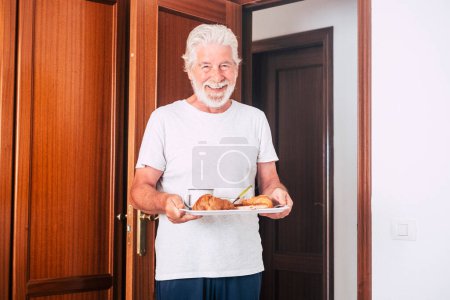 Mann zu Hause wacht einfach auf und reifer Mann steht früh auf, um das Frühstücksbett bei seiner Frau zu machen - älterer Herr und Rentner 