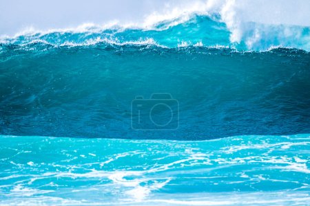 close up of beautiful and big blue and green waves breaking - pacific or Atlantic ocean - blue sea and great place to surf - white spume on the photo 