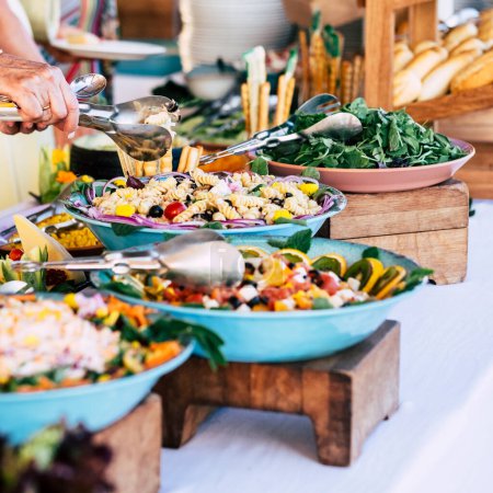 Téléchargez les photos : Gros plan sur la table pleine de nourriture avec quelqu'un qui prend des pâtes de la table pour célébrer - en image libre de droit