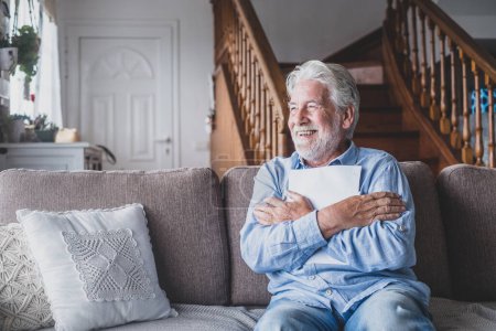 Glücklicher älterer Mann, der Krankenkassenverträge liest und die medizinischen Ergebnisse liest. Fröhlich reifer Senior umarmt ein Blatt mit den Ergebnissen oder Ergebnissen. Gesundheitstests prüfen  