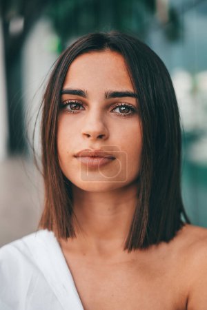 Photo for Happy young fashionable woman with short hair looking at camera outdoors. Beautiful satisfied lady with short hair smiling while facing camera. Portrait of confident female youth smiling - Royalty Free Image