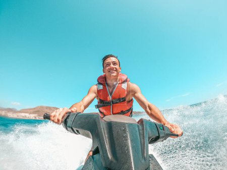 Téléchargez les photos : Homme adolescent profitant de l'été dans un jet ski au milieu de la mer s'amuser à courir seul et isolé. - en image libre de droit