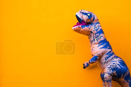 Téléchargez les photos : Un grand et grand dinosaure profiter et s'amuser avec fond orange copier et espace vide pour écrire votre texte ici - en image libre de droit