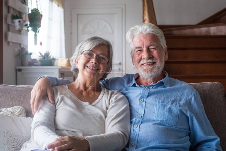 Photo for Portrait of couple of two happy and healthy seniors old people smiling and looking at the camera. Close up of mature grandparents enjoying and having fun together at home indoor. - Royalty Free Image