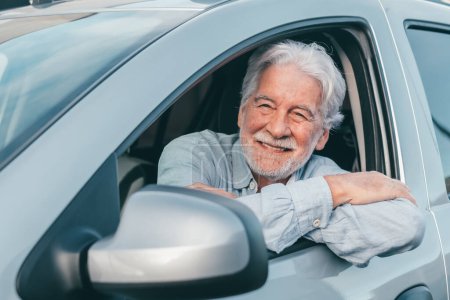 Propietario feliz mirando a la cámara con cara feliz. Guapo barbudo hombre maduro sentado relajado en su coche recién comprado mirando por la ventana sonriendo alegremente. Un viejo senior conduciendo y divirtiéndose.