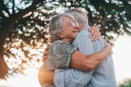 Photo for Head shot close up portrait happy grey haired middle aged woman snuggling to smiling older husband, enjoying tender moment at park. Bonding loving old family couple embracing, feeling happiness. - Royalty Free Image