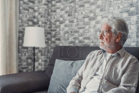 Photo for Face of senior caucasian hoary man looking away deep in sad thoughts feels lonely close up portrait, recollect memories and life moments, depressed grandfather alone indoors, yearning for wife concept - Royalty Free Image