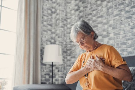 Photo for Upset stressed mature middle aged woman feeling pain ache touching chest having heart attack, sad worried senior older lady suffers from heartache at home, infarction or female heart disease concept - Royalty Free Image