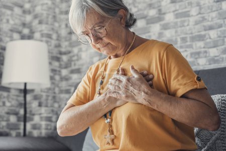 Photo for Upset stressed mature middle aged woman feeling pain ache touching chest having heart attack, sad worried senior older lady suffers from heartache at home, infarction or female heart disease concept - Royalty Free Image