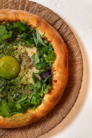 Photo for Adjarian khachapuri with suluguni cheese, yolk, cilantro and herbs on a wooden stand with a handle. - Royalty Free Image