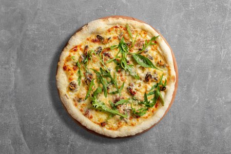 Photo for Sourdough pizza with mussels, shrimps, cream cheese sauce, arugula leaves and parmesan cheese. Pizza lies on a gray stone background. - Royalty Free Image
