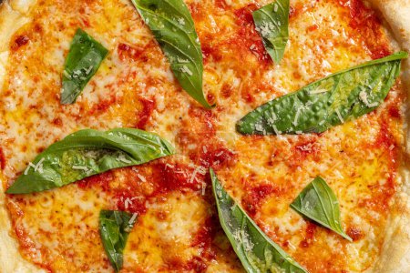 Photo for Pizza Margherita from sourdough dough with tomato sauce, mozzarella cheese and basil leaves. Pizza lies on a gray stone background. - Royalty Free Image