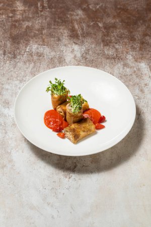Photo for Pancakes with rabbit meat, microgreen sprouts, tomato sauce and chili pepper. Food lies in a light ceramic plate on a light fabric background. - Royalty Free Image