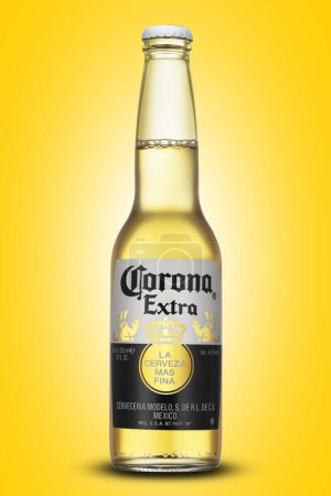 Foto de Botella de vidrio de Corona cerveza extra sobre fondo amarillo - Imagen libre de derechos