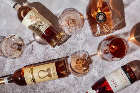 Téléchargez les photos : Quatre sortes de vin dans des verres debout sur un fond gris avec quatre bouteilles de vin - en image libre de droit