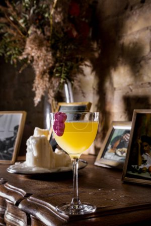 Foto de Un cóctel con zumo de naranja con gelatina pegada a la pared del vaso que se apoya sobre la mesa sobre el fondo de las fotografías - Imagen libre de derechos