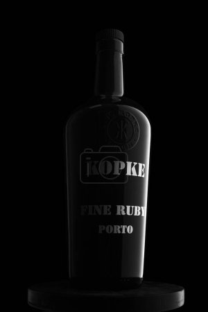 Photo for Kopke Port wine in a black bottle on a stand on a black background - Royalty Free Image