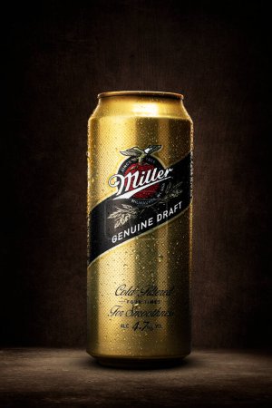 Foto de Miller Botella de cerveza de hierro en color oro de pie sobre la mesa y fondo marrón - Imagen libre de derechos
