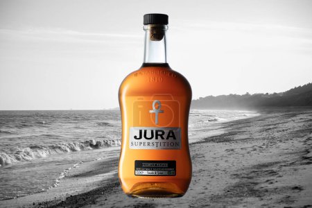 Photo for Jura superstition Whiskey bottle with discolored sea and sand background - Royalty Free Image