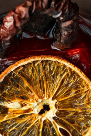 Foto de Cóctel con mezcal y vermut, licor y pera ahumada, decorado con chips de naranja en un vaso Old Fashioned. Coloque una copa con un cóctel en un barril de madera. - Imagen libre de derechos