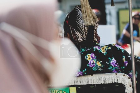 Téléchargez les photos : Vue arrière d'un wagon ou d'un chauffeur Andong sur Jalan Malioboro, Yogyakarta. Avec des vêtements de batik javanais typiques et des chapeaux blangkon. - en image libre de droit