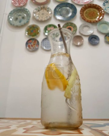 Téléchargez les photos : Boisson glacée au citron et citronnelle, très rafraîchissante. Servi dans une bouteille en verre longue attrayante, avec une paille en acier inoxydable respectueux de l'environnement. - en image libre de droit