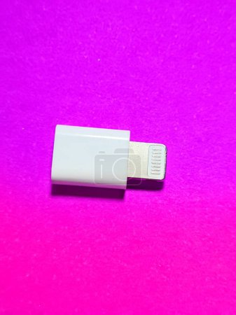 Foto de Isolated photo from a USB lightning apple OTG driver (On the go). This OTG is white and sits on a pink background. - Imagen libre de derechos