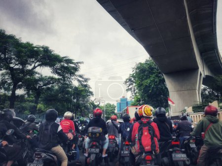 Photo for Jakarta, Indonesia in July 2022. There is a traffic jam under the Becakayu Toll Road, where motorbikes are stopping and moving slowly. - Royalty Free Image