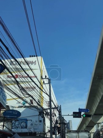 Photo for Bangkok, Thailand on July 8, 2023. ICONSIAM and SIAM Takashimaya logos covered by power poles and very messy cables on Charoen Rat Rd. Beside it there is a BTS rail. ICONSIAM is a very popular mall in bangkok. - Royalty Free Image