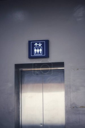 Fahrstuhl- oder Lifttafel mit blauen und weißen Linien. Es gibt 2 Männer und 1 Frau in der Form.